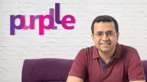 Manish Taneja, co-founder and CEO of Purplle, posing in front of the Purplle logo, representing India's leading beauty and personal care e-commerce platform.