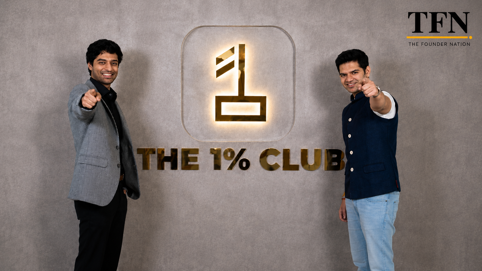 Sharan Hegde and Raghav Gupta, co-founders of 1% Club, standing in front of the 1% Club logo
