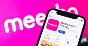 Meesho online shopping app displayed on a smartphone against the company’s pink branding.