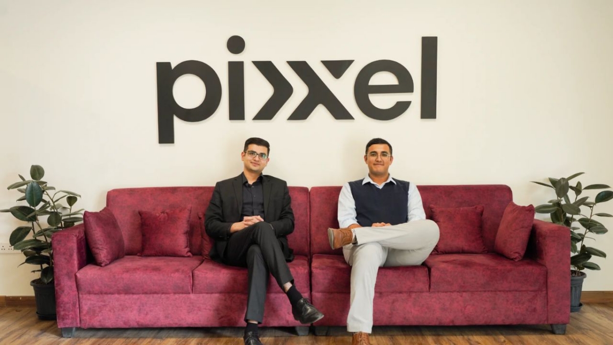 Pixxel founders seated in the company office beneath the Pixxel logo.
