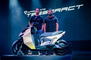 Ultraviolette Tesseract electric scooter displayed on stage with company representatives.